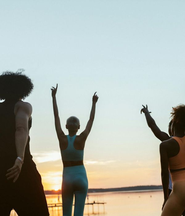 A diverse group of women practicing yoga together outdoors.